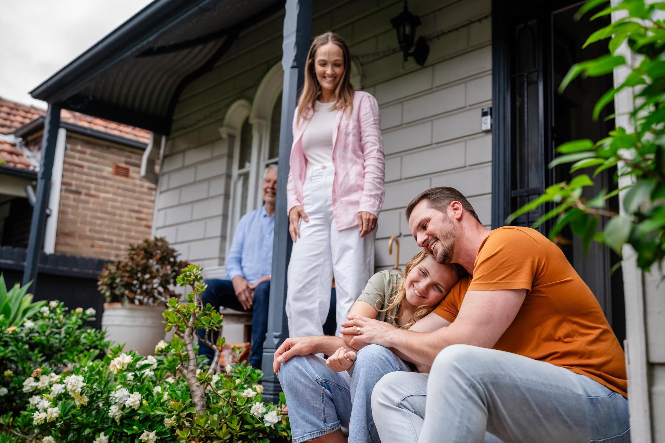 A family spending time together on the porch of their new home.