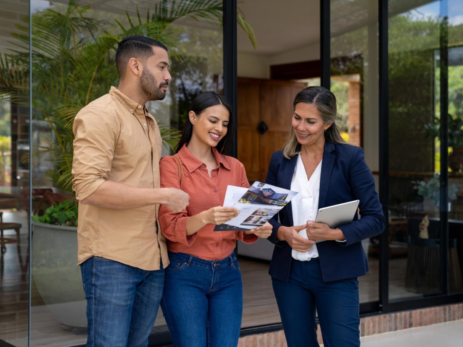 Couple talking to a real estate agent while looking to rent a house.